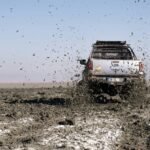 a car is driving through the mud in the desert